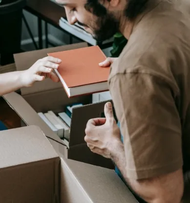 A man packing books into boxes.